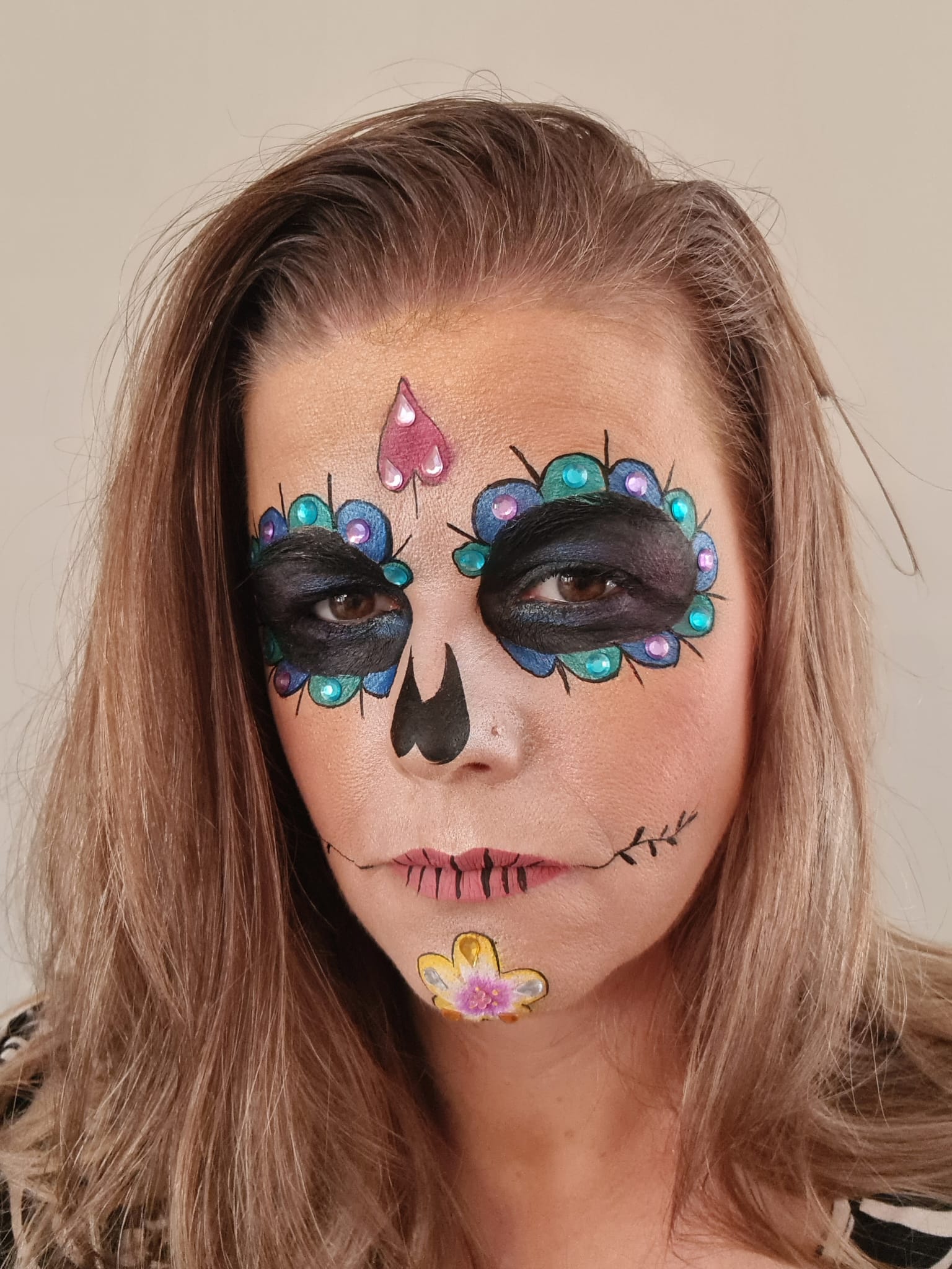 Día de Muertos schmink met gekleurde edelstenen rond de ogen