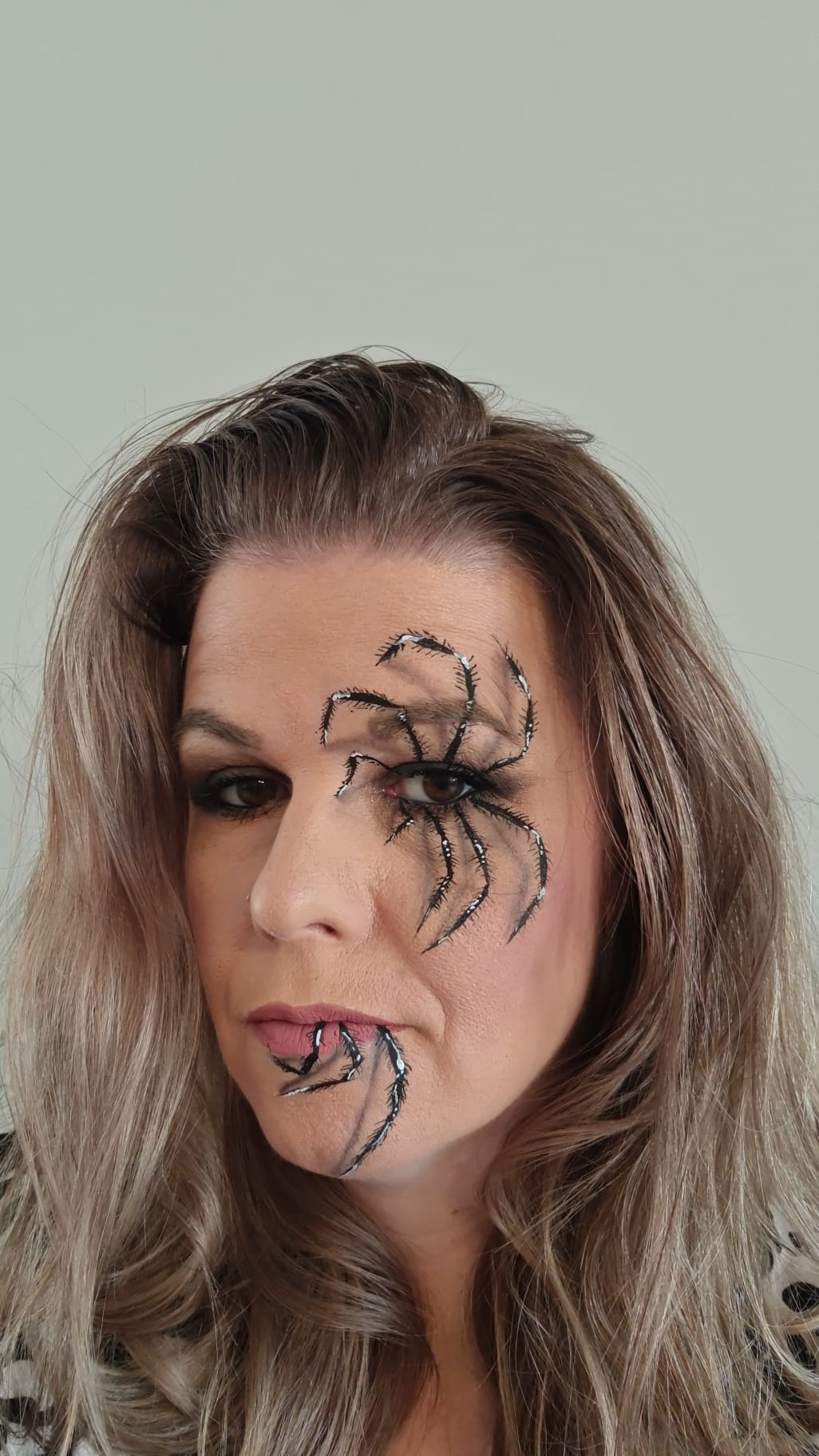 Halloween schmink van een spin over het gezicht, gemaakt door Schmink Squad