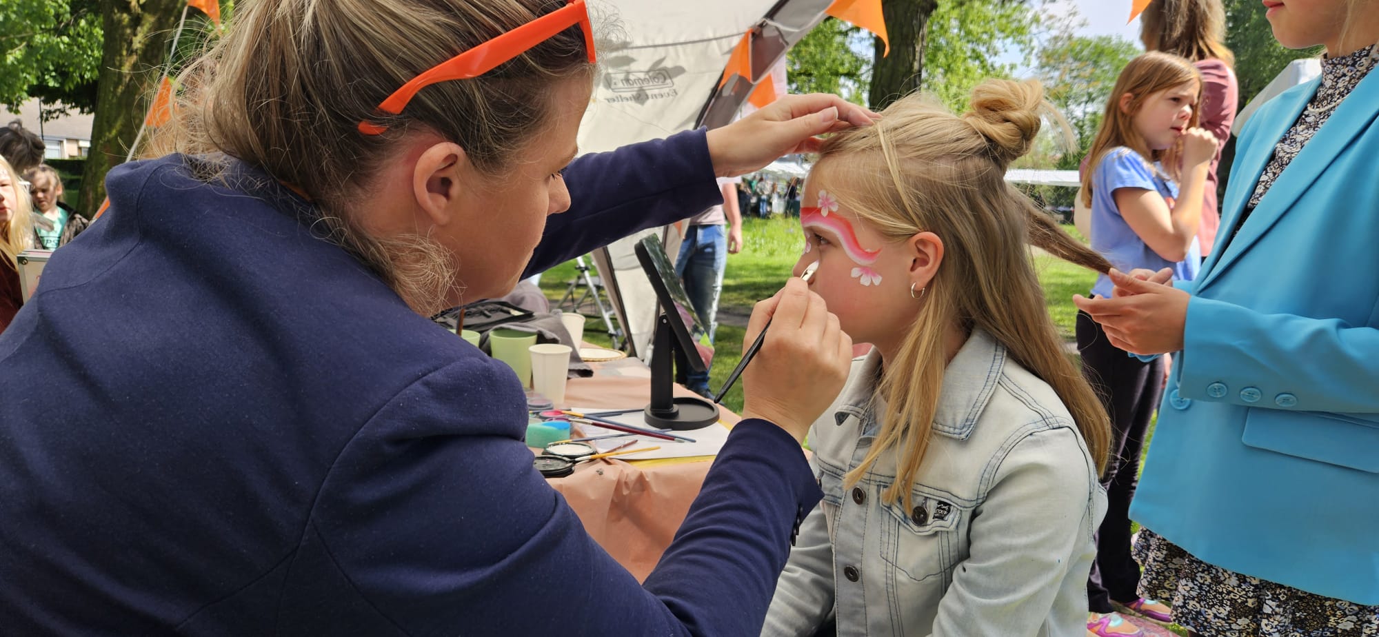 Schmink artiest van Schmink Squad schminkt het gezicht van een kind tijdens een kinderfeestje